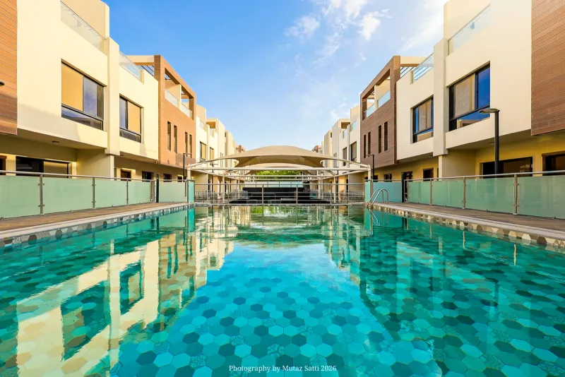 مسبح مجمّع سكني بمياه صافية تحيط به الفلل من الجانبين — تصوير عقاري في جدة بعدسة معتز ساتي