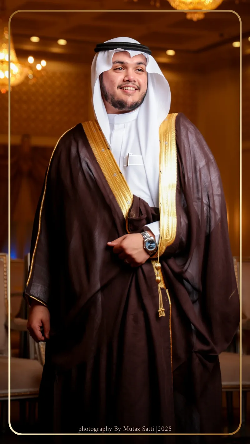 العريس بالبشت العنّابي تحت إضاءة القاعة — تصوير زواجات في جدة بعدسة معتز ساتي